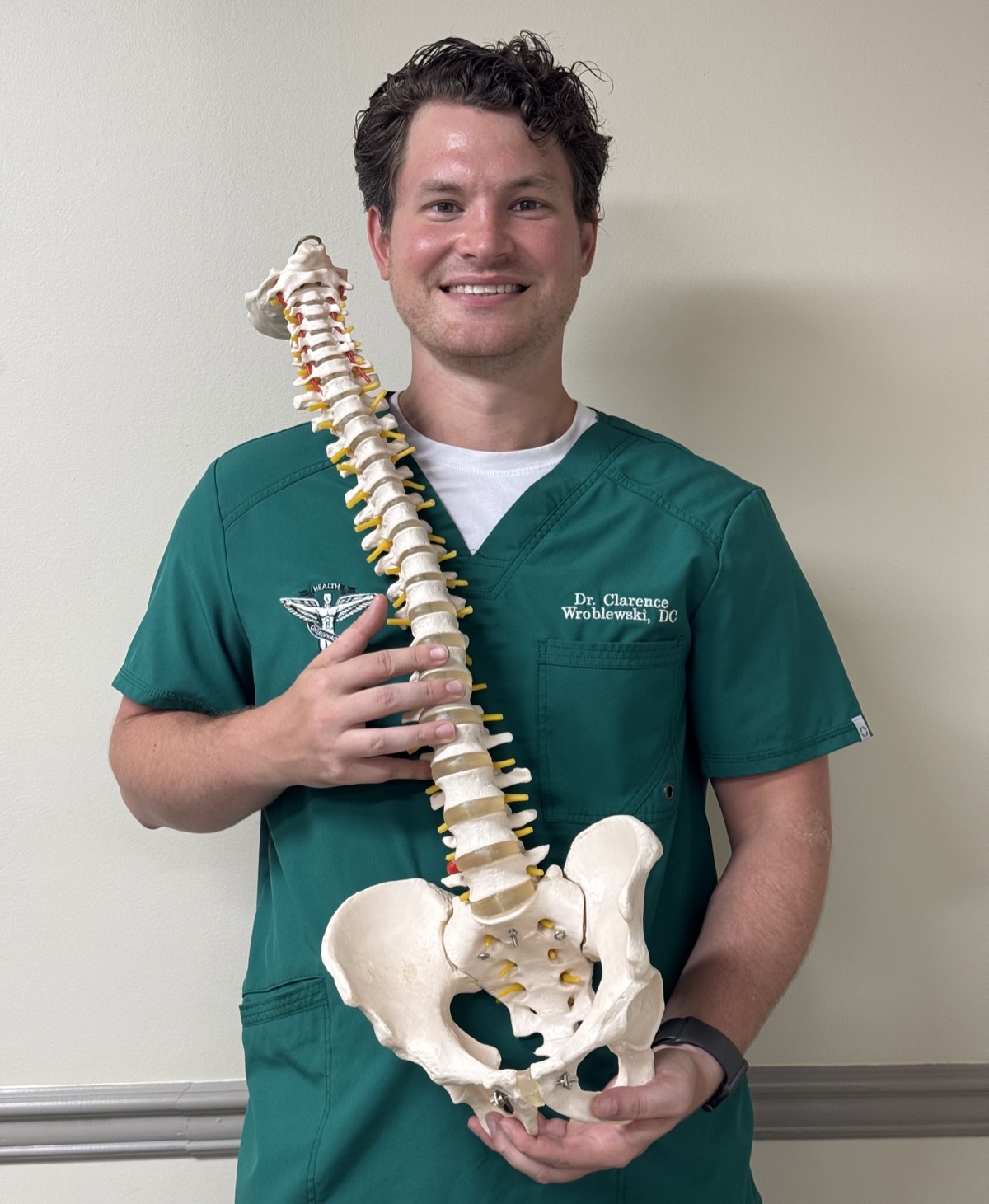 Dr. Clarence Wroblewski holding an anatomical spine model at Newman Family Chiropractic & Vital Alignment